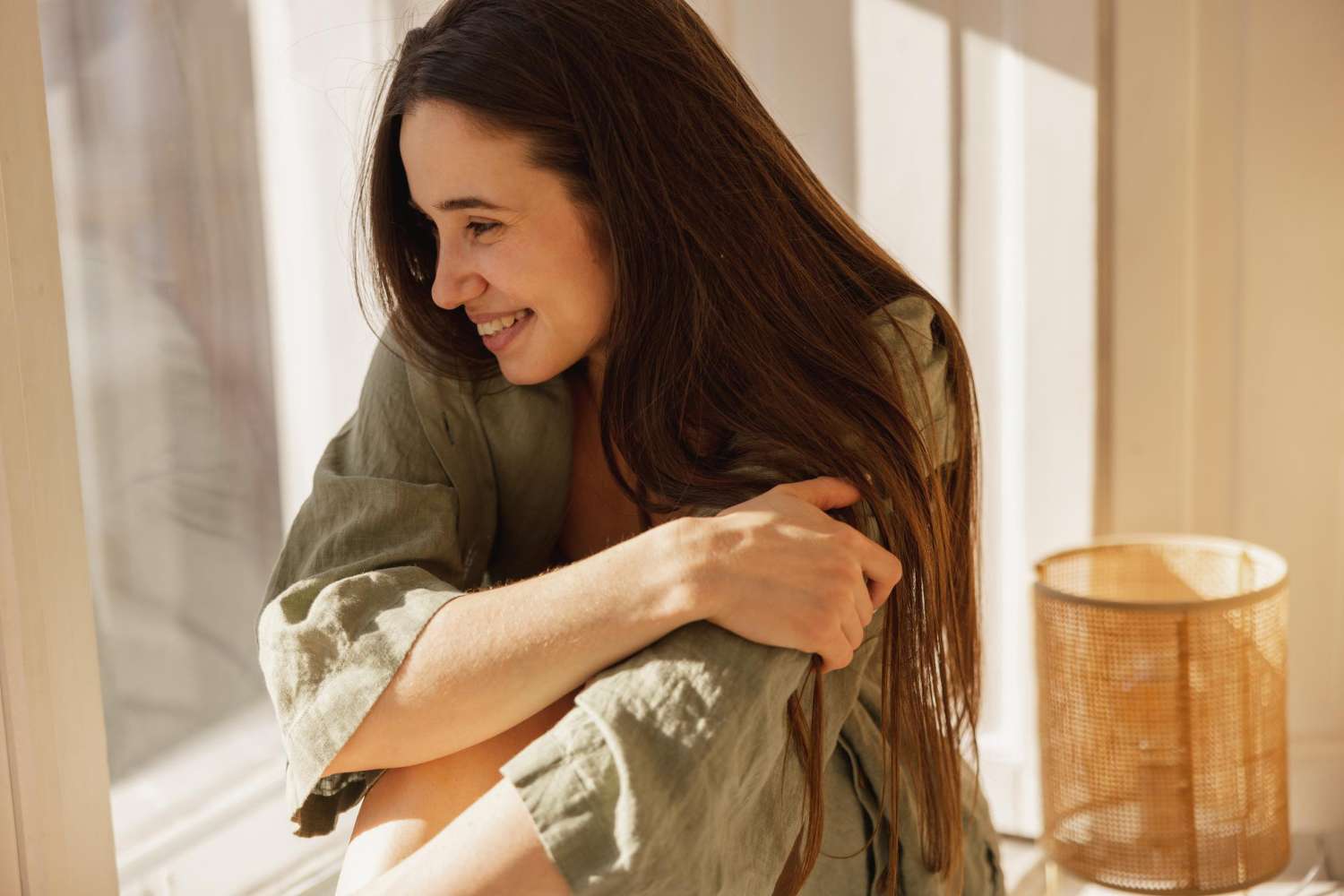 young woman smiles and hugs herself