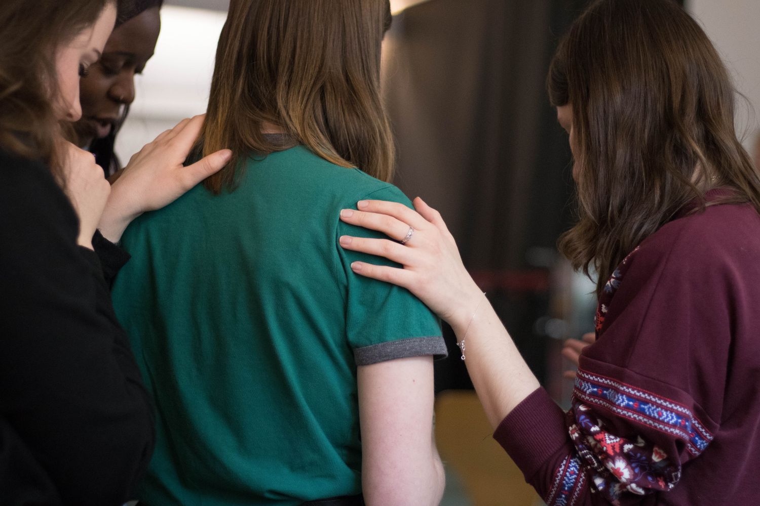 female persons touch each other's shoulders in support and listening